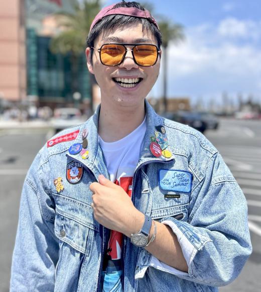 A person wearing a denim jacket and sunglasses