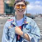 A person wearing a denim jacket and sunglasses