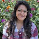 Yasmin M. photographed in front of a flower garden