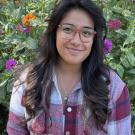 Yasmin M. photographed in front of a flower garden