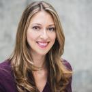 smiling, middle-aged, femme-presenting white woman with neutral background